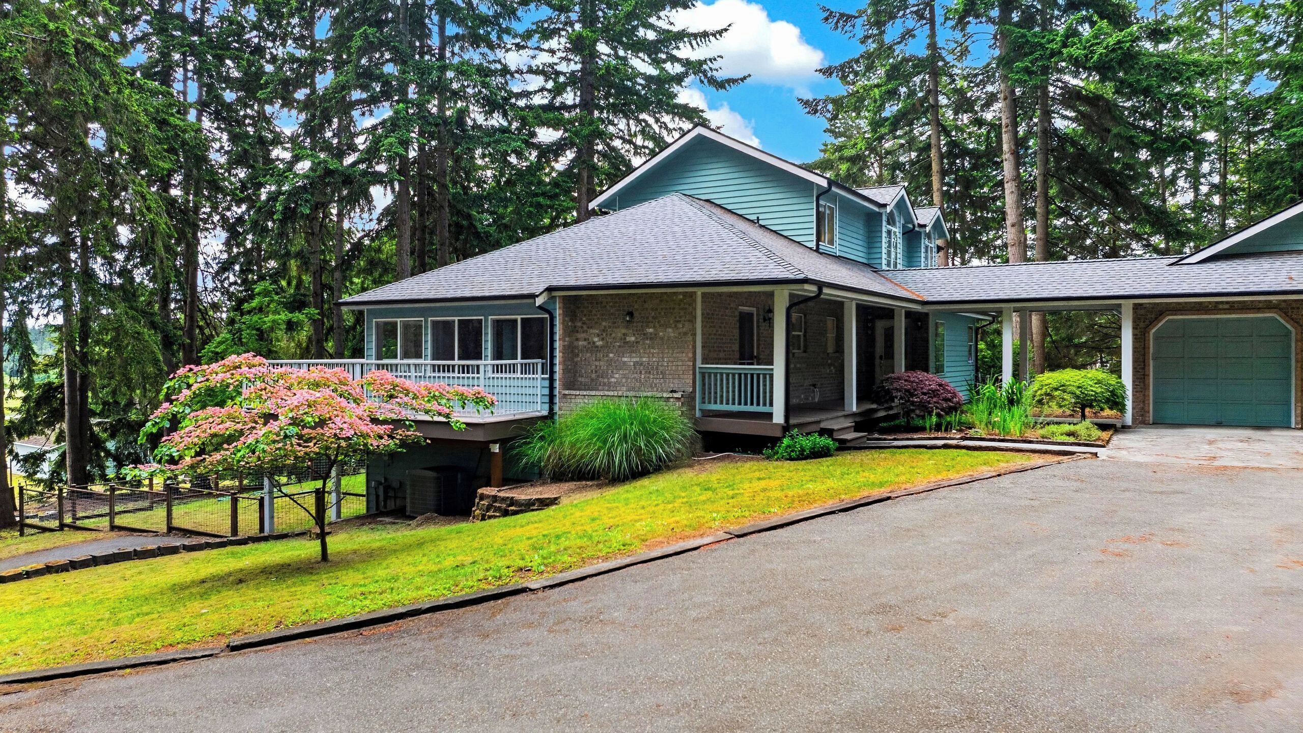 A two-story house with a covered porch, a garage, and a well-maintained lawn.