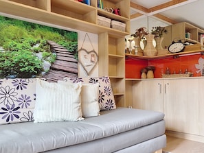 Ein Wohnzimmer mit einer Couch, einem Bücherregal und einem Wandbild.