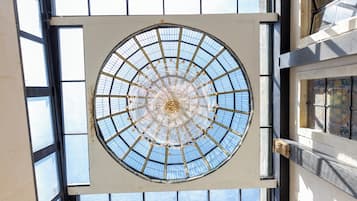 Ein großes, rundes Dachfenster mit strahlenförmigem Design, umgeben von einem Raster aus Fenstern.