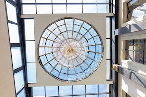Un tragaluz circular grande con un diseño radial, rodeado por una rejilla de ventanas.