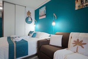 Ein Schlafzimmer mit einem Bett, einer Couch, einer Wandleuchte und einem Gemälde.