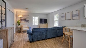 A modern living room with a sofa, a TV, and artwork on the wall.
