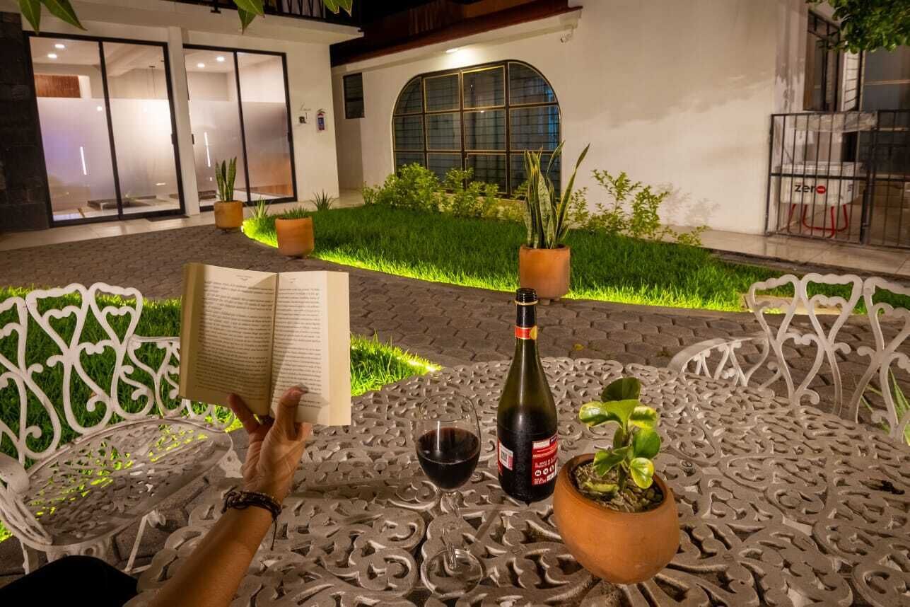 Un espace extérieur aménagé avec une table, un livre, une bouteille et un verre.