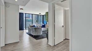 Um interior moderno com um corredor que leva a uma sala de estar com um sofá e uma mesa de centro.