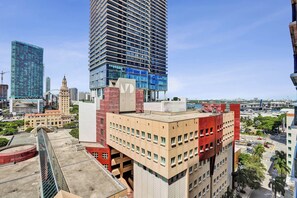 Un edifici de grans alçades amb façana de vidre modern, envoltat d'altres edificis i un cel serè.