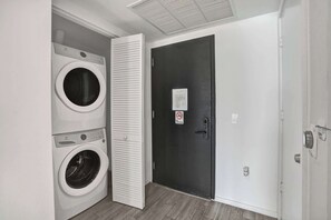 A laundry room with two front-loading washing machines and a door with a 'No Smoking' sign. - X Lounge IX Signature | 3 BR/3 Ensuite Residence (Miami)