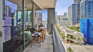 Uma varanda com vista para a paisagem urbana, incluindo edifícios altos e canteiros de obras.
