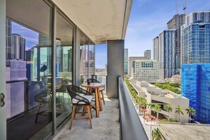 A balcony with a view of a cityscape, including high-rise buildings and construction sites. - X Lounge IX Signature | 3 BR/3 Ensuite Residence (Miami)