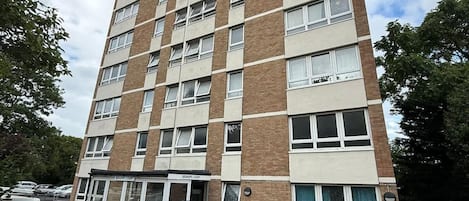A multi-story residential building with a flat facade, a ground-level entrance, and a sign indicating 'BISHOP'S COURT.'