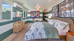 A bedroom with a bed, a dresser, a TV, and artwork on the walls. - 4BR Pool Home | 5 Min to Beach, San Juan (San Juan)