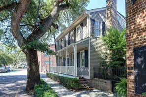A two-story house with a front porch, brick chimney, and a street view. - The Williams House of 1816 | Courtyard + Parking (Savannah)