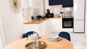 Een moderne keuken met witte kasten, een magnetron en een koelkast.