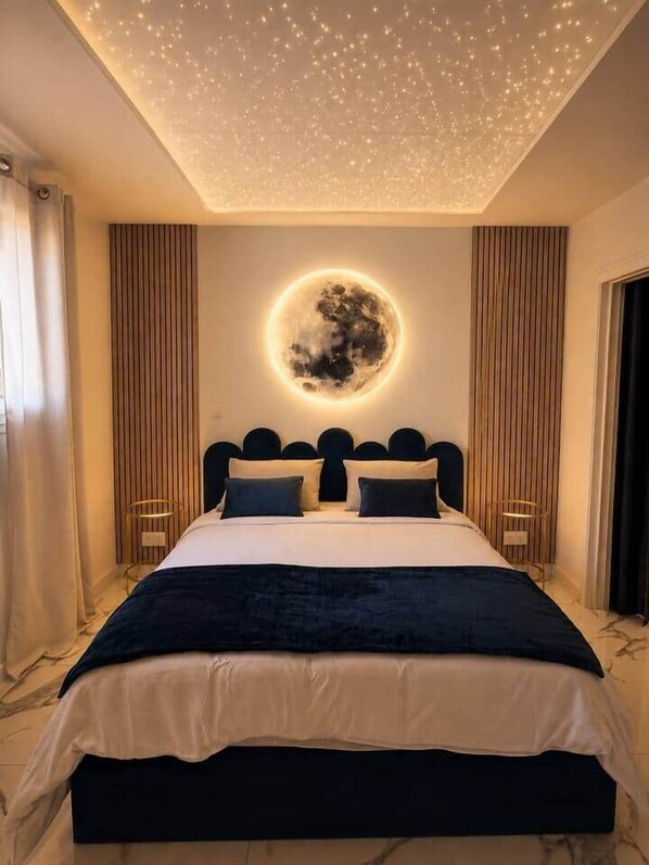 Ein Schlafzimmer mit einem Bett, einer runden Wanddekoration und einer Decke mit Lampen.