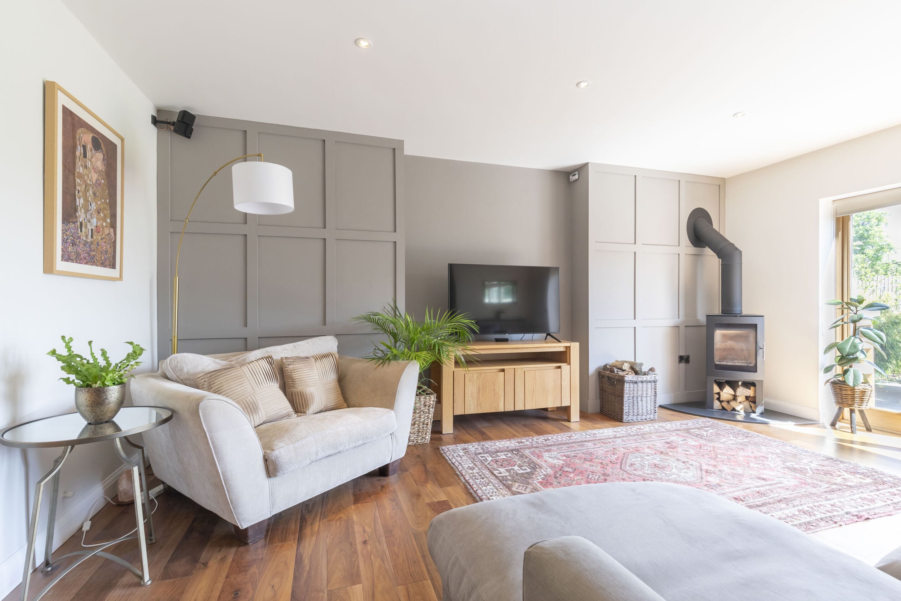 A living room with a sofa, TV, wooden cabinet, and a fireplace.