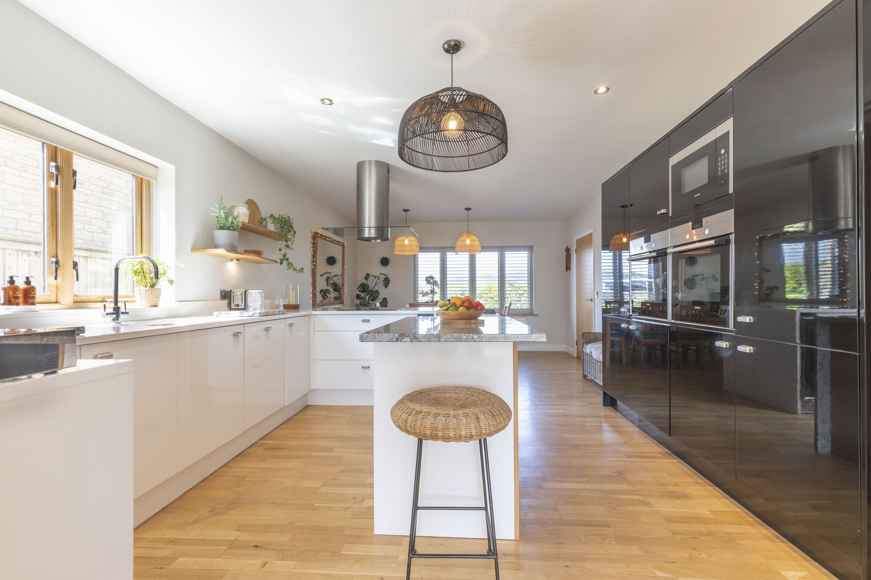 A modern kitchen with a central island, stainless steel appliances, and pendant lighting.