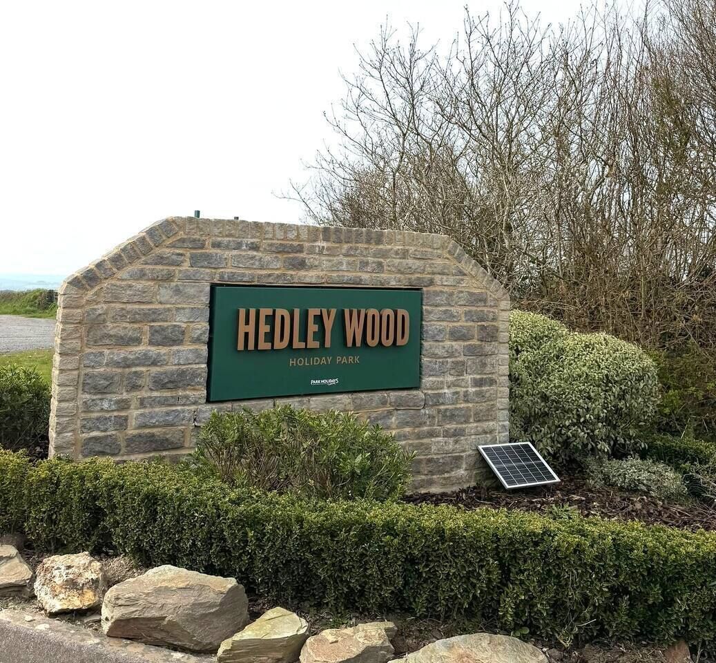 A stone sign with 'Hedley Wood Holiday Park' written on it.