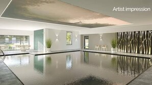 Una piscina interior moderna con paredes de vidrio transparente, diseño minimalista y vistas al exterior.