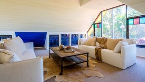A modern living room with a sofa, a coffee table, and a rug.