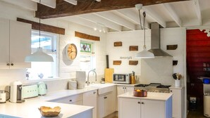 A modern kitchen with white cabinetry, a built-in microwave, a gas stove, and a hanging light fixture. - Petana Farm Stay - Pet-friendly Country Retreat (Morton)