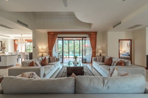 A spacious living room with two sofas, a coffee table, and a view of the outdoors. - Lakeview 4BR villa 4 minutes to Bangtao, Layan Beach with Laguna Golf course (Choeng Thale)