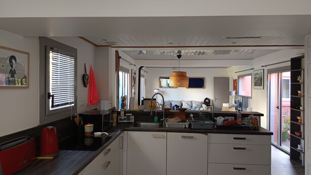 Une cuisine moderne avec des meubles blancs, un plan de travail en bois et un grand îlot central.