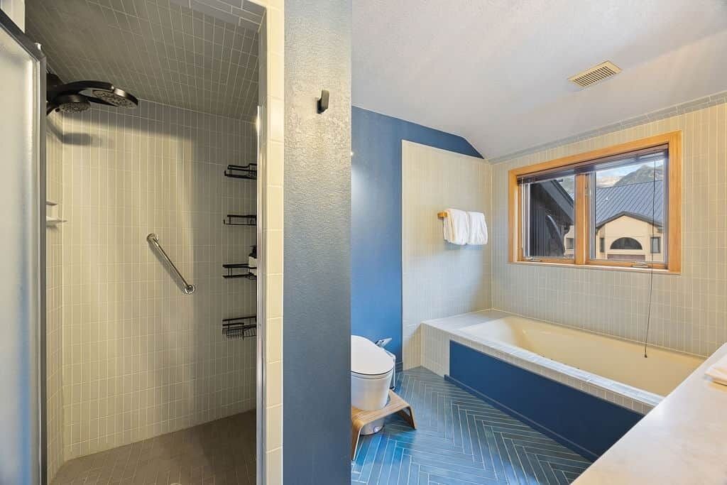 A bathroom with a shower, toilet, and bathtub.