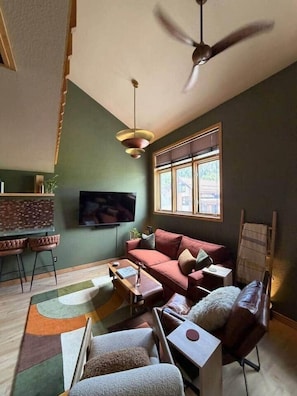 A living room with a sofa, armchairs, a coffee table, a TV, and a ceiling fan. - The Western View: Pool, Hot Tub, Ski, Repeat (Telluride)