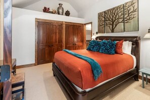 A bedroom with a large bed, wooden wardrobe, and a painting on the wall. - Ski, Hike & Unwind — Heart of Telluride — 3bd/3ba (Telluride)