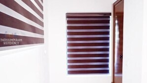 Una habitación pequeña con una ventana, una puerta y un letrero en la pared.