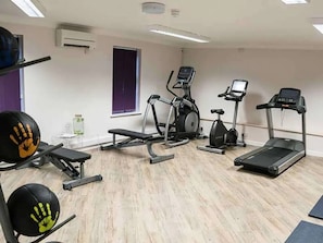 A gym with treadmills, an elliptical, and free weights.