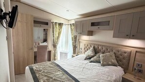 Un dormitorio con cama, mesita de noche, armario y espejo.