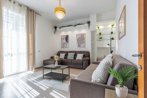 Een moderne woonkamer met een bank, salontafel en een potplant.