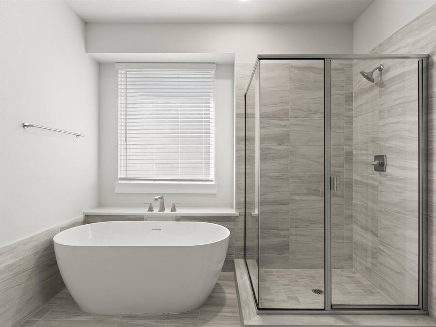 A modern bathroom with a freestanding bathtub, a glass-enclosed shower, and a window with blinds.