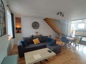 Ein modernes Wohnzimmer mit einer Couch, einem Couchtisch und einer Treppe zu einer weiteren Ebene.