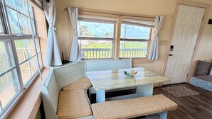 A room with a bench seating area, a table, and a door. - Sargent Sunset & Fishing Retreat (Bay City)