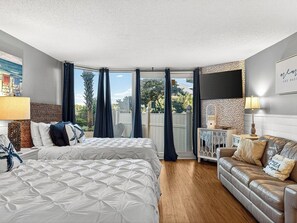 A bedroom with a bed, a sofa, a desk, and a window with curtains. - Beachside Studio: Updated, Ground Floor near Tootsie's wPool, Patio, Free Chairs (Panama City Beach)