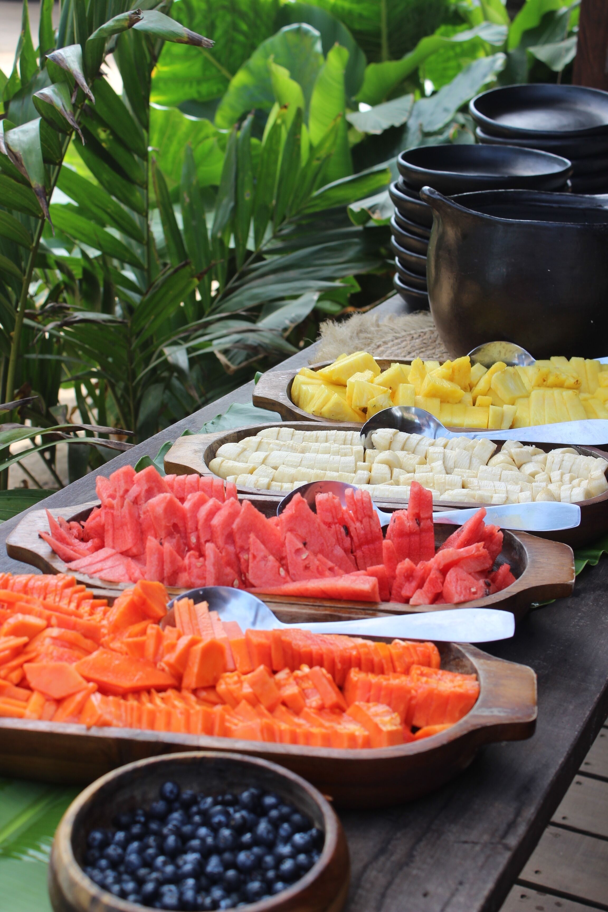 A buffet table with various fruits and vegetables.