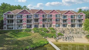 A multi-story hotel with balconies, a landscaped garden, and a water feature.