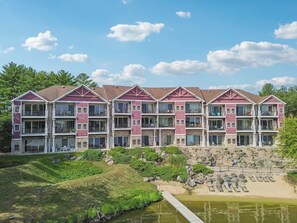 A multi-story hotel with balconies, a landscaped garden, and a water feature.