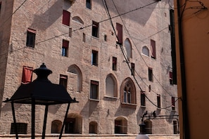 A historic building with arched windows and a traditional lantern. - Enjoy a stylish holiday in this space in the heart of Bologna. A modern apartment welcomes you in the heart of Bologna's historic center, overlooking Piazza Maggiore. Located on the first floor of a typical Bolognese building, the apartment features a sp (Bologna)