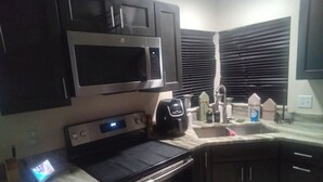 Eine Küche mit Mikrowelle, Backofen und Kaffeemaschine.