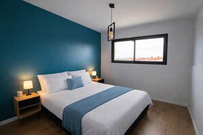 Ein Schlafzimmer mit Bett, Nachttischlampen, einem Fenster und Blick.