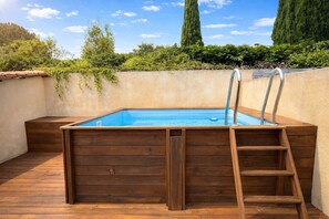 Ein Pool im Freien mit Holzstufen und einer Leiter.