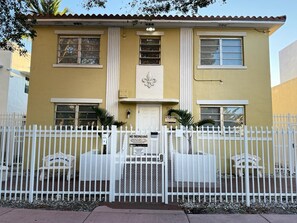 A two-story building with a white fence, a gated entrance, and a sign indicating no trespassing. - South Beach Gem, Walk to Ocean Drive & Beach (Miami Beach)