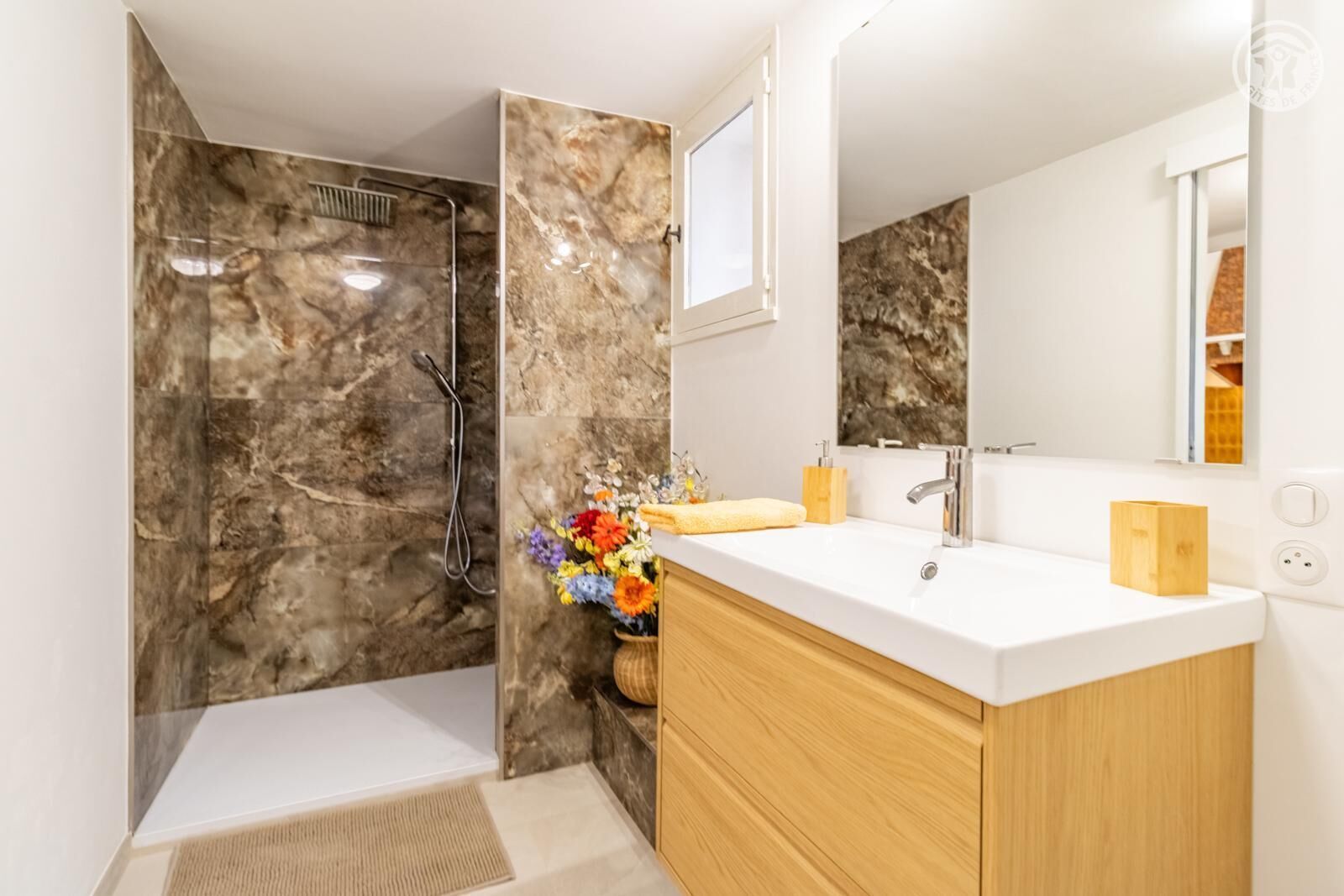 A modern bathroom with a shower, a sink, and a mirror.