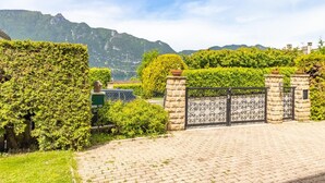 A paved driveway leading to a gated entrance with a mountain backdrop. - LES CIGALES - TRESSERVE (TRESSERVE)