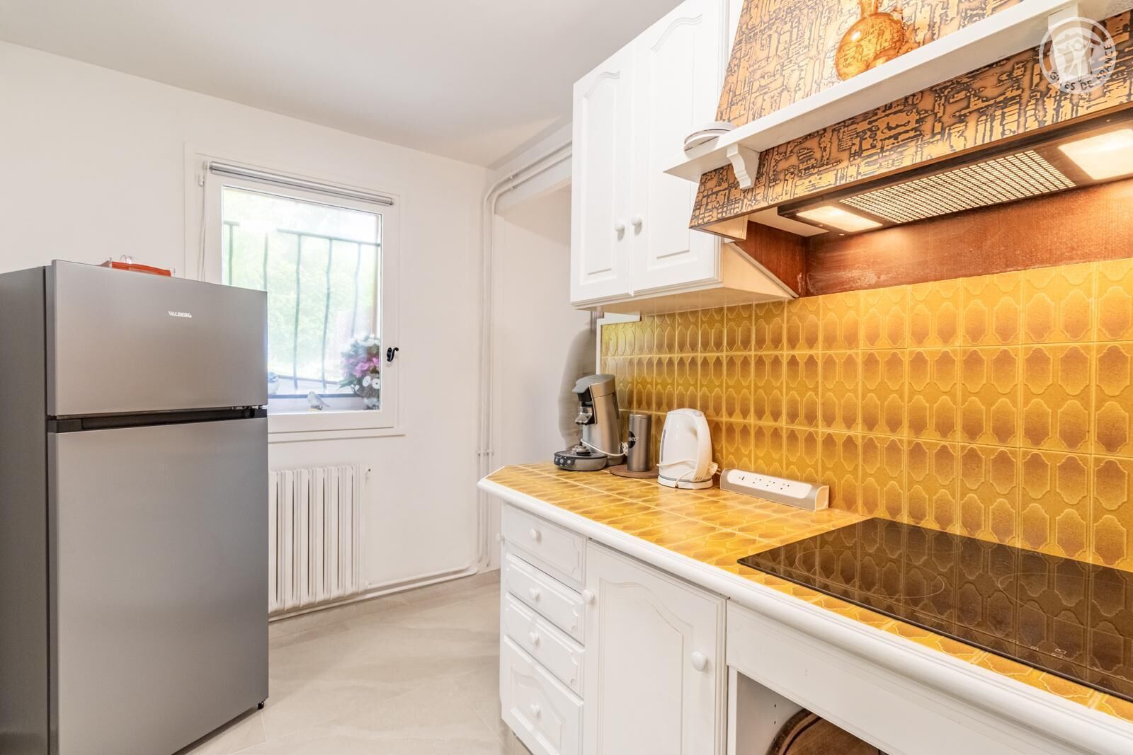 A compact kitchen with a refrigerator, a coffee maker, and a microwave.