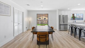 Une cuisine moderne avec une table à manger, des chaises et un réfrigérateur.
