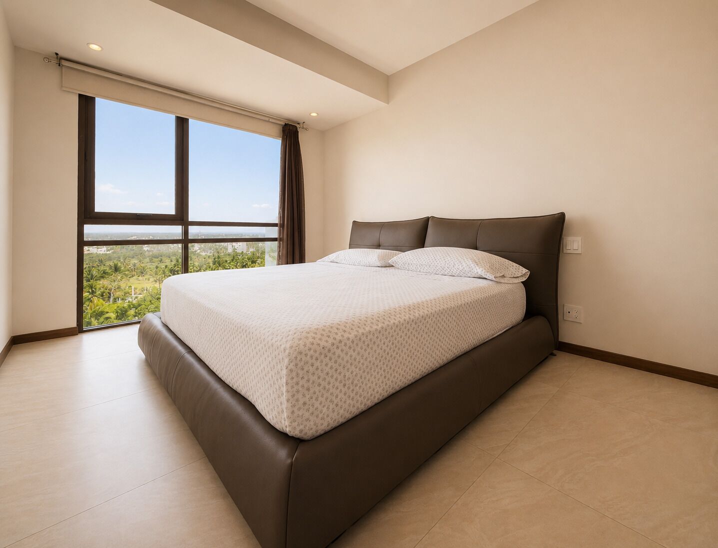 Un dormitorio con una cama grande, vistas a zonas verdes por una ventana y un diseño moderno.