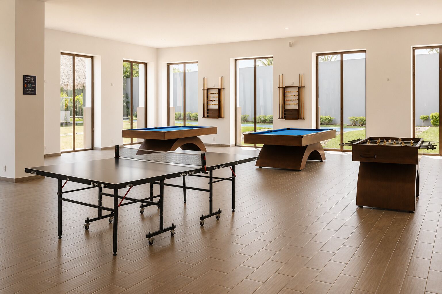 Una habitación amplia con mesa de ping pong, mesa de futbolín y mesa de billar.